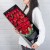 33朵红玫瑰，尤加利叶底部包围，底部黑色雾面纸包裹，银灰色丝带束扎，一个黑色长方形礼盒，